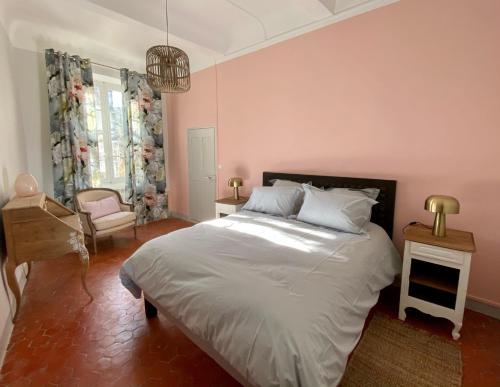 a bedroom with a large bed and a chair at Domaine Les Mûriers in Brignoles