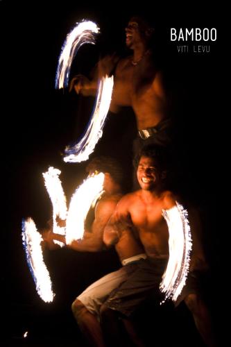 a group of men with fire sparklers in the dark at Bamboo Backpackers in Nadi