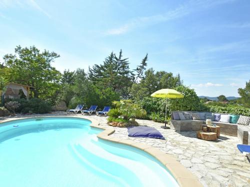 uma piscina com cadeiras e um guarda-sol em Quiet villa near the beach at Fr jus em Fréjus