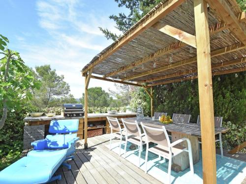 um pátio exterior com uma pérgola de madeira, uma mesa e cadeiras em Quiet villa near the beach at Fr jus em Fréjus