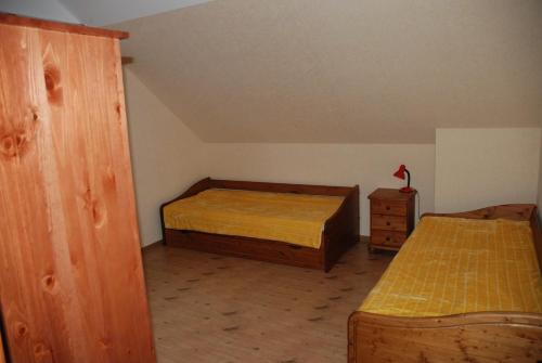 Habitación pequeña con 2 camas y armario de madera. en Amber Cottage, en Jūrmala