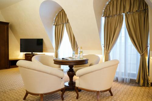 a room with a table and chairs and a television at Residence City Garden - Certificate of Excellence Top 10 BEST Five-Stars City Hotels for 2024 awarded by HTIF in Plovdiv