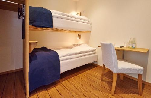 a bedroom with bunk beds with a desk and a chair at Fridas Hotell in Höganäs