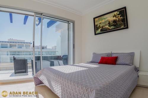 a bedroom with a bed and a large window at Adan Beach Residence, Beach Front Apartments in Aourir