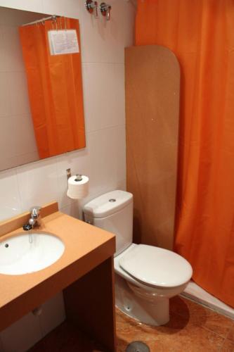a bathroom with a toilet and a sink and a mirror at Pension Segura in Murcia