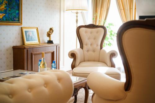 a living room with a chair and a table at Residence City Garden - Certificate of Excellence Top 10 BEST Five-Stars City Hotels for 2024 awarded by HTIF in Plovdiv