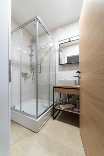 a bathroom with a glass shower and a sink at Apartmani Špoljar in Županja