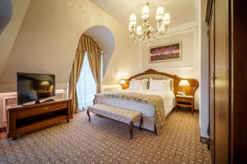a bedroom with a bed and a television and a chandelier at Residence City Garden - Certificate of Excellence Top 10 BEST Five-Stars City Hotels for 2024 awarded by HTIF in Plovdiv