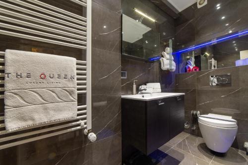 a bathroom with a toilet and a sink and a mirror at The Queen Luxury Apartments - Villa Carlotta in Luxembourg