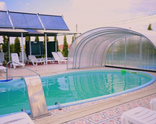 a swimming pool with a glass wall around it at VitaPark Solnechniy Provans in Satanov
