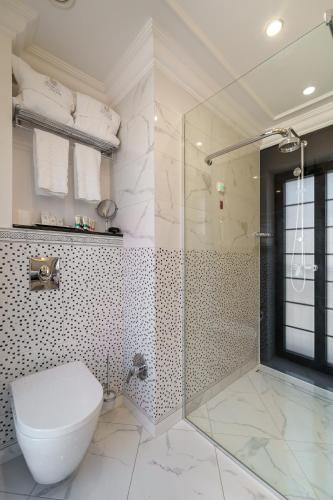 a bathroom with a toilet and a glass shower at Residence City Garden - Certificate of Excellence Top 10 BEST Five-Stars City Hotels for 2024 awarded by HTIF in Plovdiv