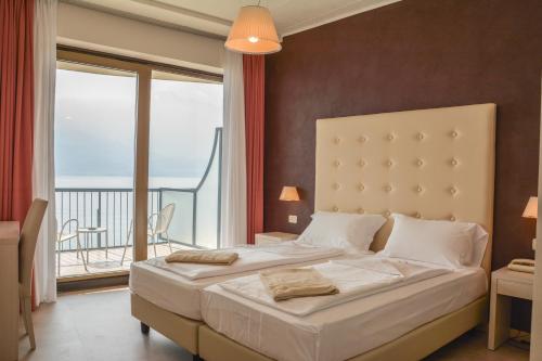 a bedroom with a large bed and a balcony at HOTEL ASTOR in Limone sul Garda
