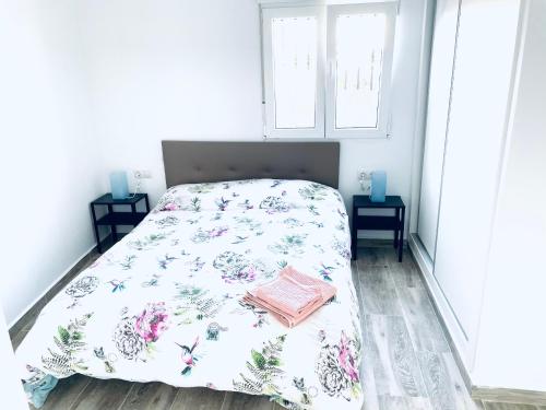 a bedroom with a bed with a floral bedspread at Super Exclusive Bungalow in Benalmádena