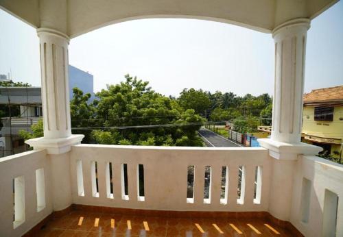 a white balcony with a view of a street at Hotel Castle Manor - Auroville Beach in Pondicherry