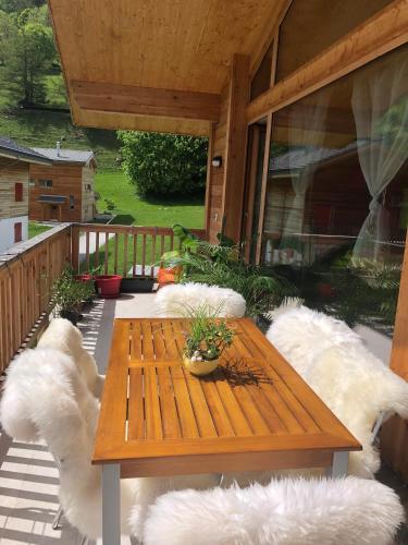 a wooden table on a deck with white pillows at Chalet Breithorn- Perfect for Holiday with Amazing View! in Obergesteln