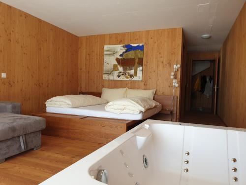 a room with a bed and a bath tub at Chalet Breithorn- Perfect for Holiday with Amazing View! in Obergesteln