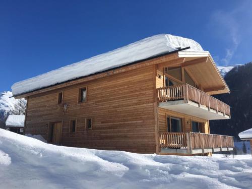 a log cabin with a balcony in the snow at Chalet Breithorn- Perfect for Holiday with Amazing View! in Obergesteln