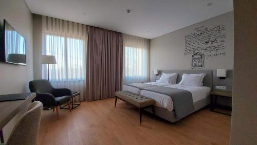 een hotelkamer met een groot bed en een stoel bij Casa da Torre - Viseu in Viseu