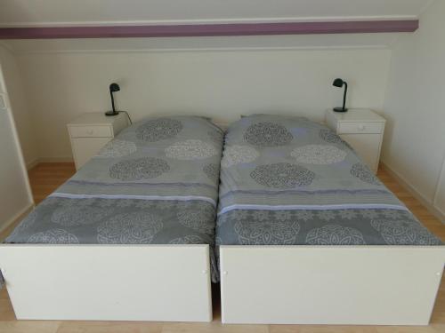 1 cama en una habitación con 2 mesitas de noche en Kamerverhuur Advenco, en Aagtekerke