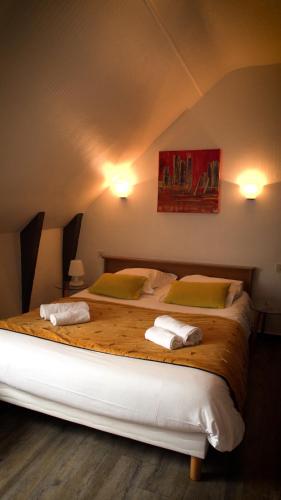 a bedroom with two beds with towels on them at Hotel Le Derby in Quimper