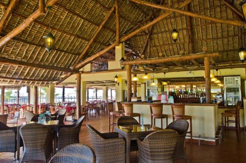 a restaurant with tables and chairs and a bar at White Sands Hotel in Dar es Salaam