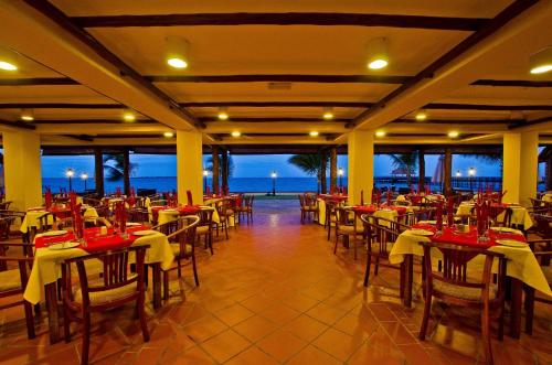a restaurant with tables and chairs with a view of the ocean at White Sands Hotel in Dar es Salaam
