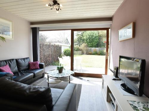 a living room with a couch and a tv at Holiday Home in Bredene Terrace Fenced Garden in Bredene