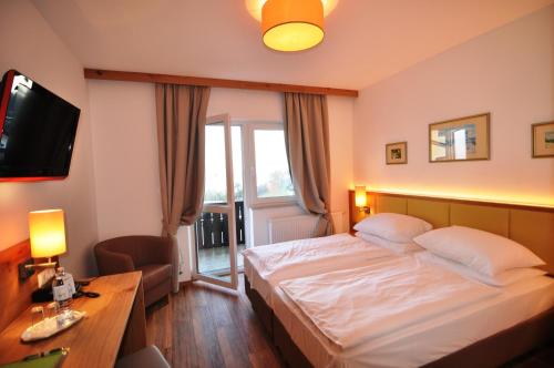 ein Hotelzimmer mit einem Bett und einem TV in der Unterkunft Wienerwaldhof Rieger in Tullnerbach-Lawies