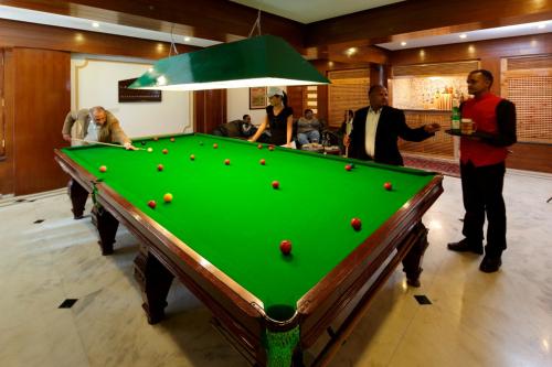 a group of men standing around a pool table at Manuallaya The Resort & Spa in Manāli