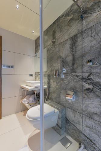 a bathroom with a toilet and a glass shower at Hotel Airlink in Mumbai