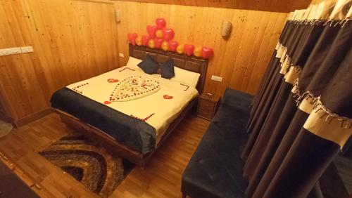 - une chambre avec un lit doté de ballons rouges dans l'établissement Ibni Springs, à Madikeri