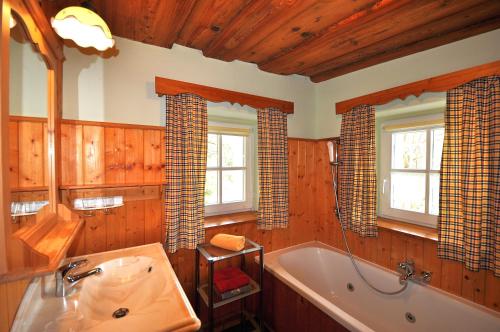 a bathroom with a bath tub and a sink at Altes Gehöft am Lormanberg in Kirchberg an der Raab
