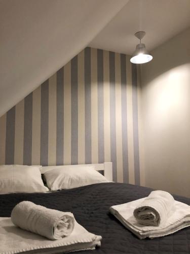 a bedroom with a bed with towels on it at Dom Tkacki - Apartamenty - Pokoje - Jacuzzi in Kudowa-Zdrój