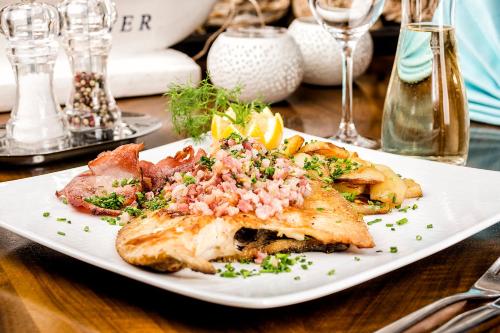a white plate of food on a table at Hotel Neuwarft in Dagebüll