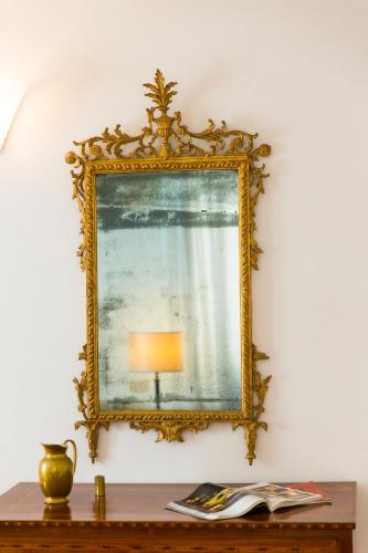 a mirror on a wall with a lamp on a table at Zafferano Rooftop Terrace Tower House in San Gimignano