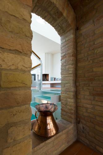 a large copper vase sitting in a brick wall at Zafferano Rooftop Terrace Tower House in San Gimignano