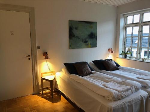 um quarto com uma cama grande e uma janela em Herligheden em Bjerringbro
