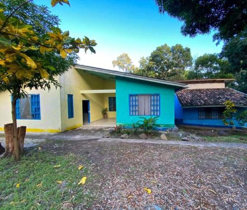 una casa azul y blanca con un árbol delante en Hostal Juan Lindo en San Pedro Sula