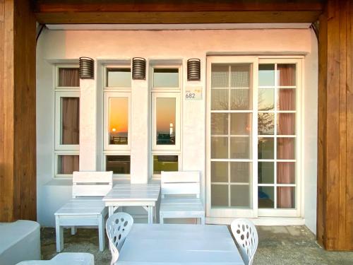 a table and chairs in front of a building with windows at Seyan Inn in Eluan