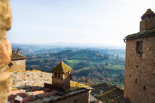 a view of a city from a building with a view of a valley at Zafferano Rooftop Terrace Tower House in San Gimignano