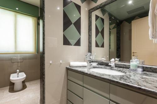 La salle de bains est pourvue d'un lavabo et de toilettes. dans l'établissement Villa Primavera - Homelike Villas, à Capoterra