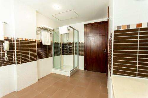 a bathroom with a walk in shower and a glass door at Best Western Premier Accra Airport Hotel in Accra