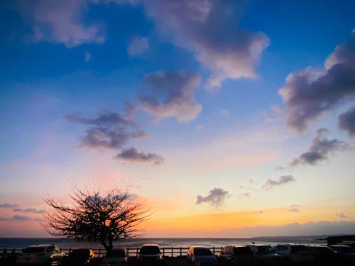 a sunset with cars parked in a parking lot at Seyan Inn in Eluan
