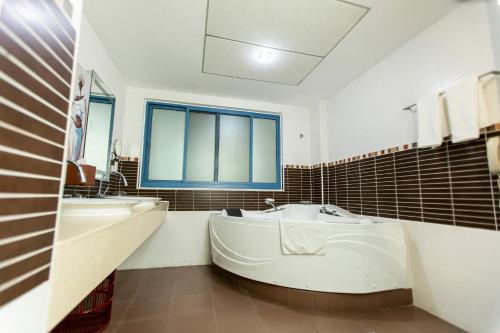 a large white bathroom with a tub and a sink at Best Western Premier Accra Airport Hotel in Accra