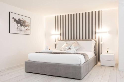 a white bedroom with a large bed with two lamps at Unforgettable Split Level Jacuzzi Suite Navona - Top Collection in Rome