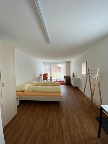 a bedroom with a large bed and a wooden floor at Ferienwohnungen JHS in Seewis im Prättigau
