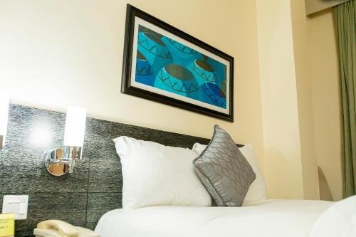 a bedroom with a bed and a picture on the wall at Best Western Premier Accra Airport Hotel in Accra