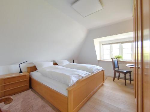 a bedroom with a bed with a desk and a chair at Ferienwohnung Gül Waanang in Nebel