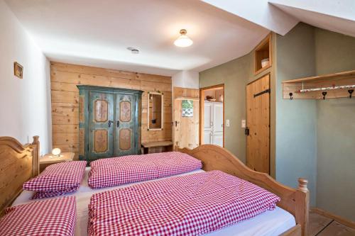 a bedroom with two beds with red and white sheets at Ferienwohnung Wachsbichl in Unterammergau