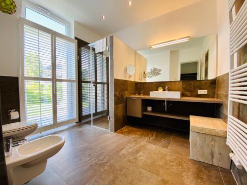 a bathroom with a sink and a toilet and a mirror at Ferienhaus am Lotsenstieg 6 in Karlshagen